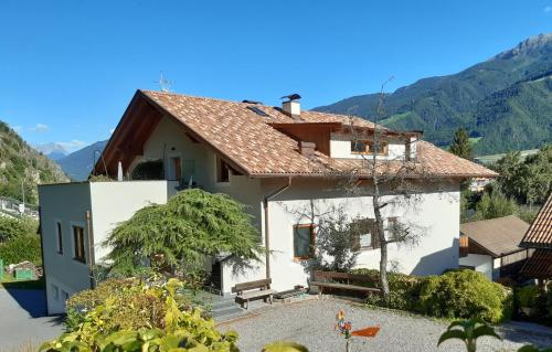 a white house with mountains in the background at Brunnerhof in Naturno