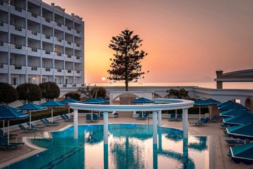 uma vista para um hotel com uma piscina e guarda-sóis em Mitsis Grand Hotel in Ilha de Rhodes