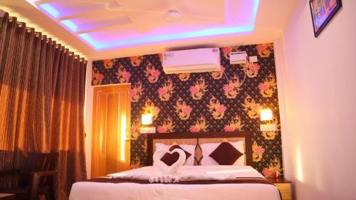 een hotelkamer met een bed met een blauw licht bij MAHIRA RESIDENCY in Port Blair