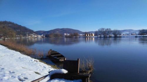 a boat sitting on a river in the snow at Holiday homes Piralo in Kostajnica