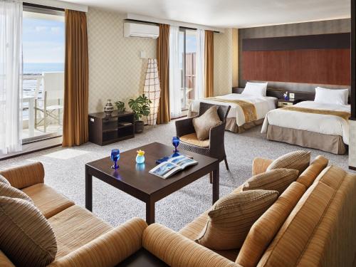 a hotel room with two beds and a living room at Cypress Resort Kumejima in Kumejima