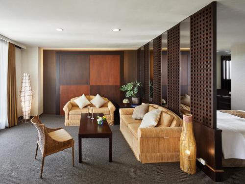 a hotel room with a couch and a bed at Cypress Resort Kumejima in Kumejima