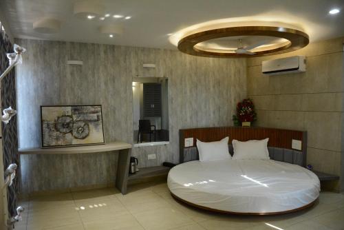 Hotel Darshan SP Ring Road في Naroda: غرفة نوم فيها سرير ابيض كبير