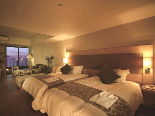 a hotel room with two beds and a living room at Moon Ocean Ginowan Hotel & Residence in Ginowan