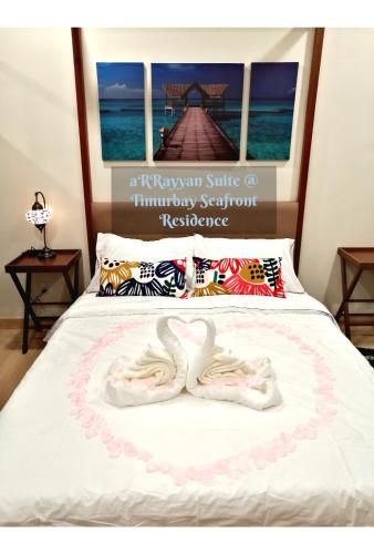 a bed with two white slippers on it at Timurbay Seafront Residence aRRayyan Suites in Kuantan