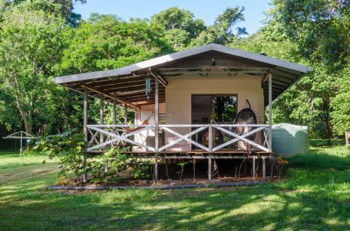 a small house with a porch in the grass at Epiphyte B & B in Cape Tribulation