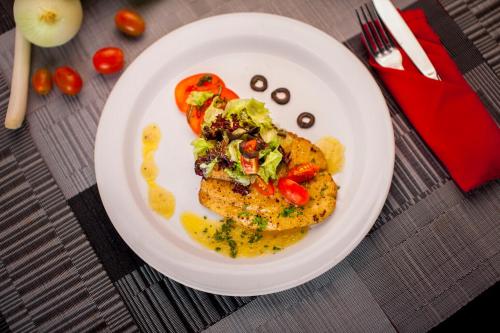 a white plate with food on a table at The Radiant Hotel in Kuta
