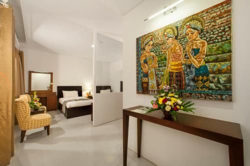 a living room with a large painting on the wall at The Radiant Hotel & Spa in Kuta