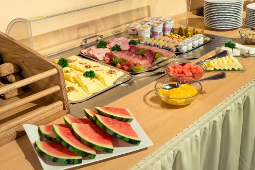 a buffet with fruits and vegetables on a table at Hotel Bayernhof in Greding
