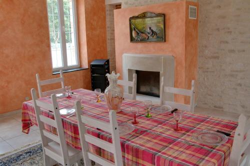 a dining room with a table and a fireplace at Gite de Villaine in Theillay