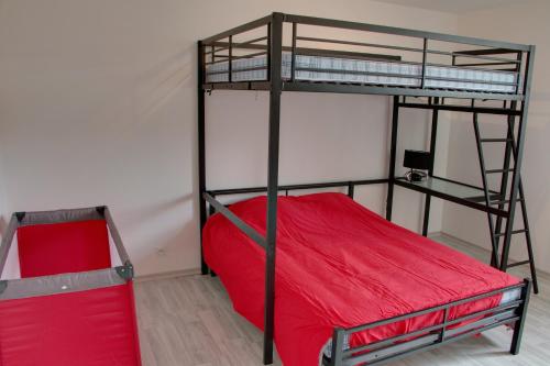 a bedroom with two bunk beds and a red mattress at Gite de Villaine in Theillay