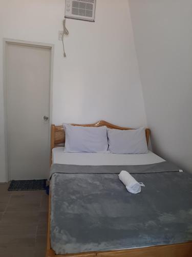 a bedroom with a bed with a pillow on it at travis homestay in Siquijor