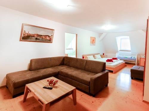 ein Wohnzimmer mit einem Sofa und einem Tisch in der Unterkunft Hotel Bayernhof in Greding