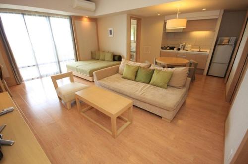 a living room with a couch and a table at Moon Ocean Ginowan Hotel & Residence in Ginowan