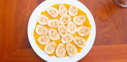 un piatto di banane sopra una ciotola di frutta di Lodge By Tam Coc lake a Ninh Binh