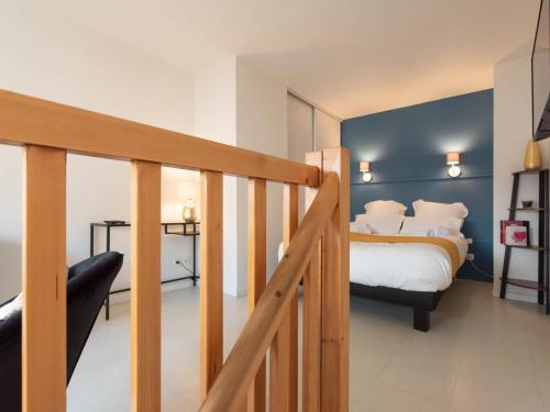 1 dormitorio con cama y escalera en Duplex coquet avec PARKING proche centre-ville de Lyon, en Villeurbanne