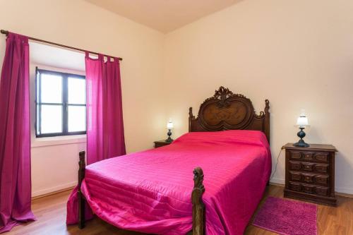 a bedroom with a bed with pink sheets and a window at Casa Amoreira - Quinta Amoreira in Faro