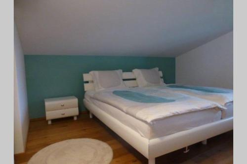ein Schlafzimmer mit einem großen Bett und einer grünen Wand in der Unterkunft Casa Ual / Capaul in Laax