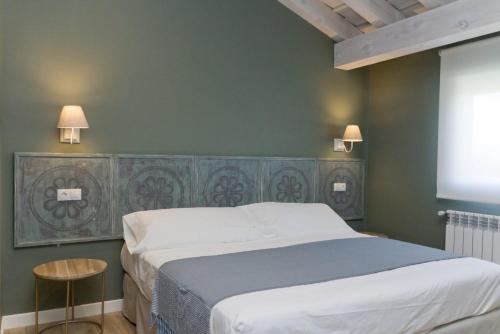 um quarto com uma cama grande e duas luzes na parede em Miradiez Segovia em Espirdo
