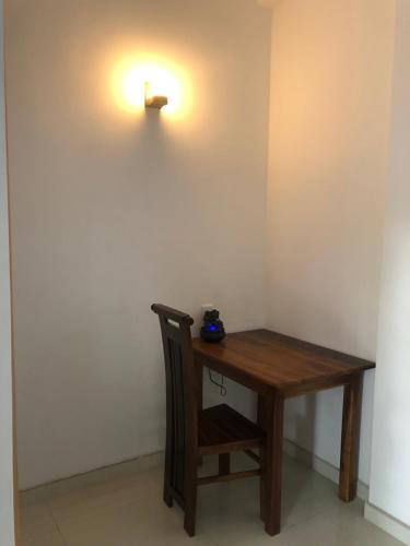 a wooden table with a light on the wall at Lanka Villa Mirissa in Mirissa