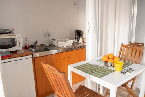 - une cuisine avec une table et un bol d'oranges dans l'établissement Paleo Kalamaki, à Isthmia