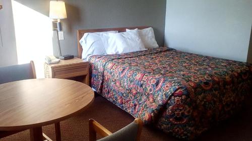 a hotel room with a bed and a table at KCI Lodge in Kansas City