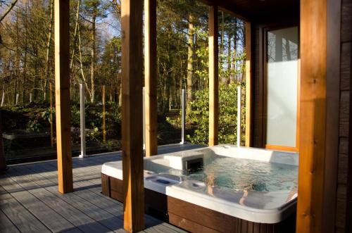 uma banheira de hidromassagem numa casa com janelas em Hollicarrs - Honeycomb Lodge em York