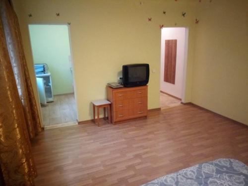 a living room with a tv on a dresser and a door at Viestura apartamenti in Daugavpils