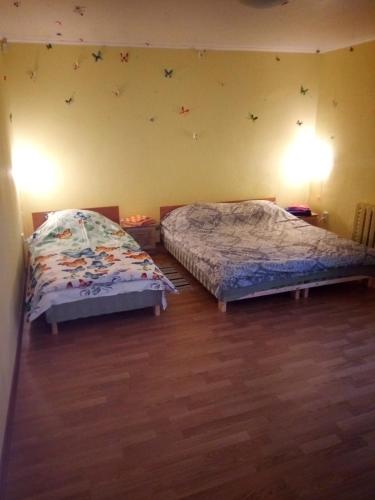 a bedroom with two beds and a wall with butterflies at Viestura apartamenti in Daugavpils