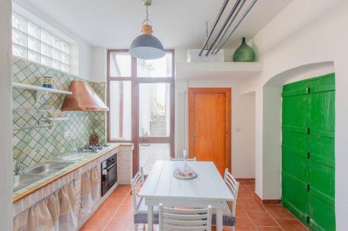 a kitchen with a white table and green cabinets at Casa Leo in Carovigno