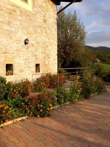 a stone building with flowers in front of it at Poggio d'Incanto in Bettola