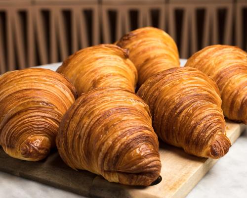 a bunch of croissants sitting on a cutting board at Leman Locke in London