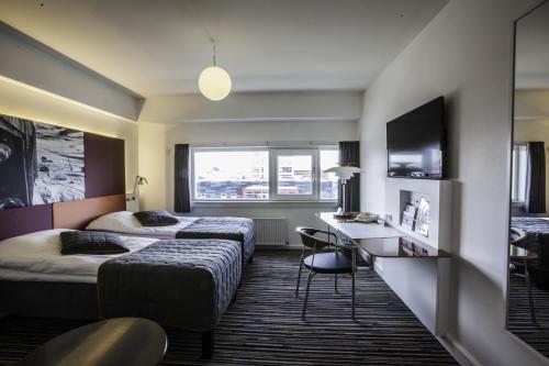a hotel room with two beds and a desk at Hotel Hans Egede in Nuuk