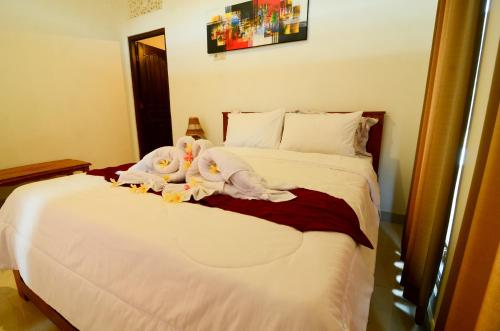 two stuffed animals sitting on top of a bed at Volcano Lake View in Kintamani