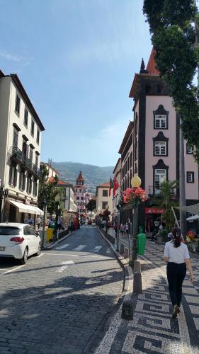 a woman walking down a street in a town at Edificio Charles 202 in Funchal