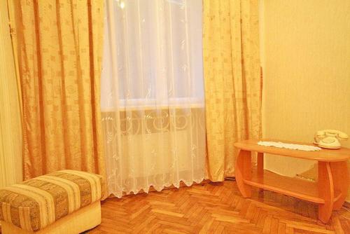 a room with a bed, chair and a window at Park and Opera Apartments in Lviv