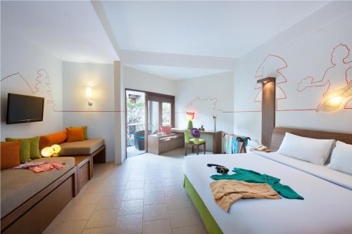 a hotel room with a bed and a couch at ibis Styles Bali Legian - CHSE Certified in Legian
