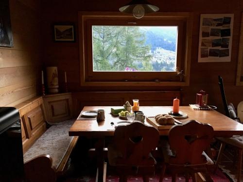 a kitchen with a wooden table and a window at Grand Pra in Haudères