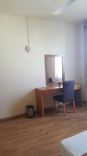 a desk with a mirror and a chair in a room at The Monalysa Suites & Residence in Grand Baie