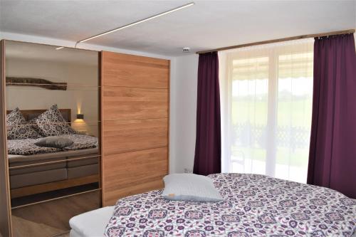 ein Schlafzimmer mit einem Bett und einem großen Fenster in der Unterkunft Landhaus Senn in Füssen