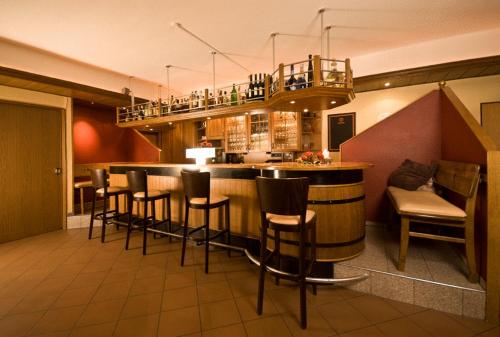 a bar in a restaurant with chairs and a counter at Alte - Post - Hotel in Schöppingen