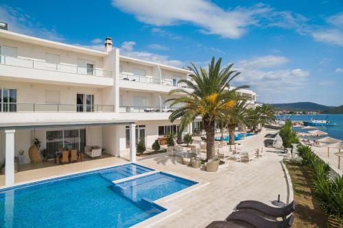 eine Außenansicht eines Hotels mit Swimmingpool in der Unterkunft Perla Resort in Rogoznica