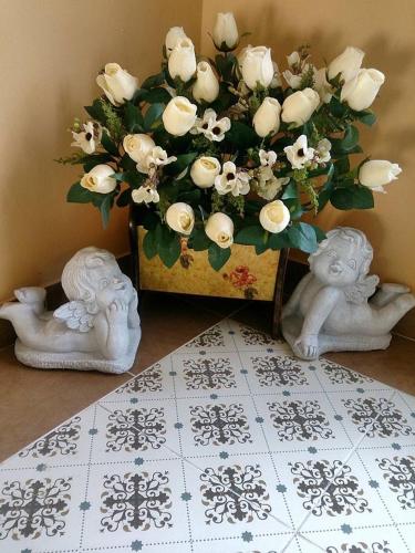 a vase with a bouquet of white roses at Kesorn Boutique Residence at 8 Riew in Chachoengsao
