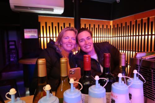 two people sitting at a table with bottles of wine at B&B MIKAWA 2 - Kanazawa Fish Harbour in Kanazawa