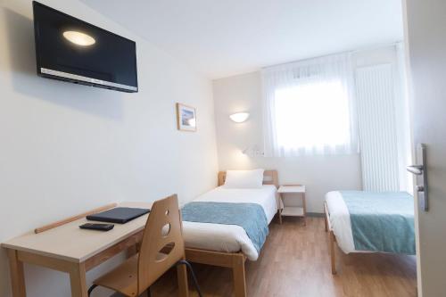 a small room with two beds and a desk at Centre Jean XXIII in Annecy