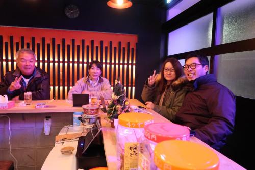 a group of people sitting at a table at B&B MIKAWA 2 - Kanazawa Fish Harbour in Kanazawa