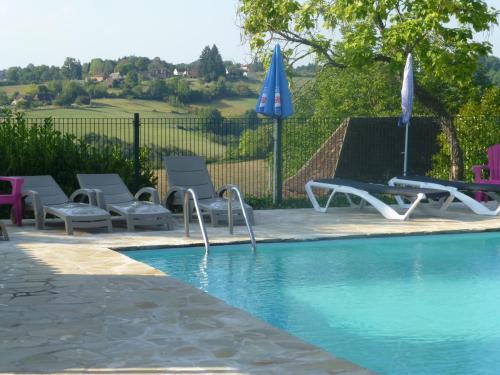 - une piscine avec des chaises et des parasols à côté dans l'établissement Camping Les Terrasses de Dordogne, à Rouffignac-Saint-Cernin-de-Reilhac