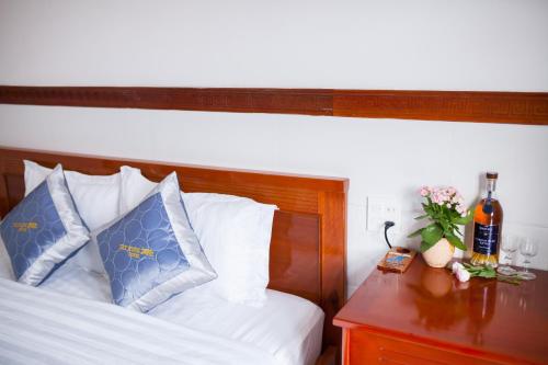 a bedroom with a bed with blue pillows and a table at Thy Hung legacy hotel in Tuy Hoa