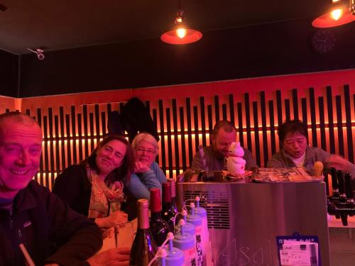 a group of people sitting at a bar at B&B MIKAWA 2 - Kanazawa Fish Harbour in Kanazawa