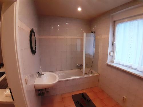 een badkamer met een wastafel, een douche en een bad bij FeWo Ines in Lauscha